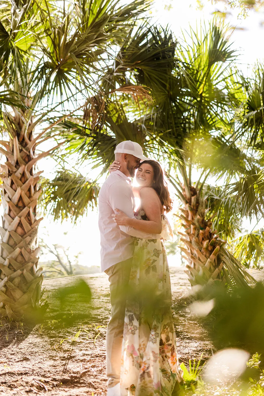 Backlit engagement portrait under palms