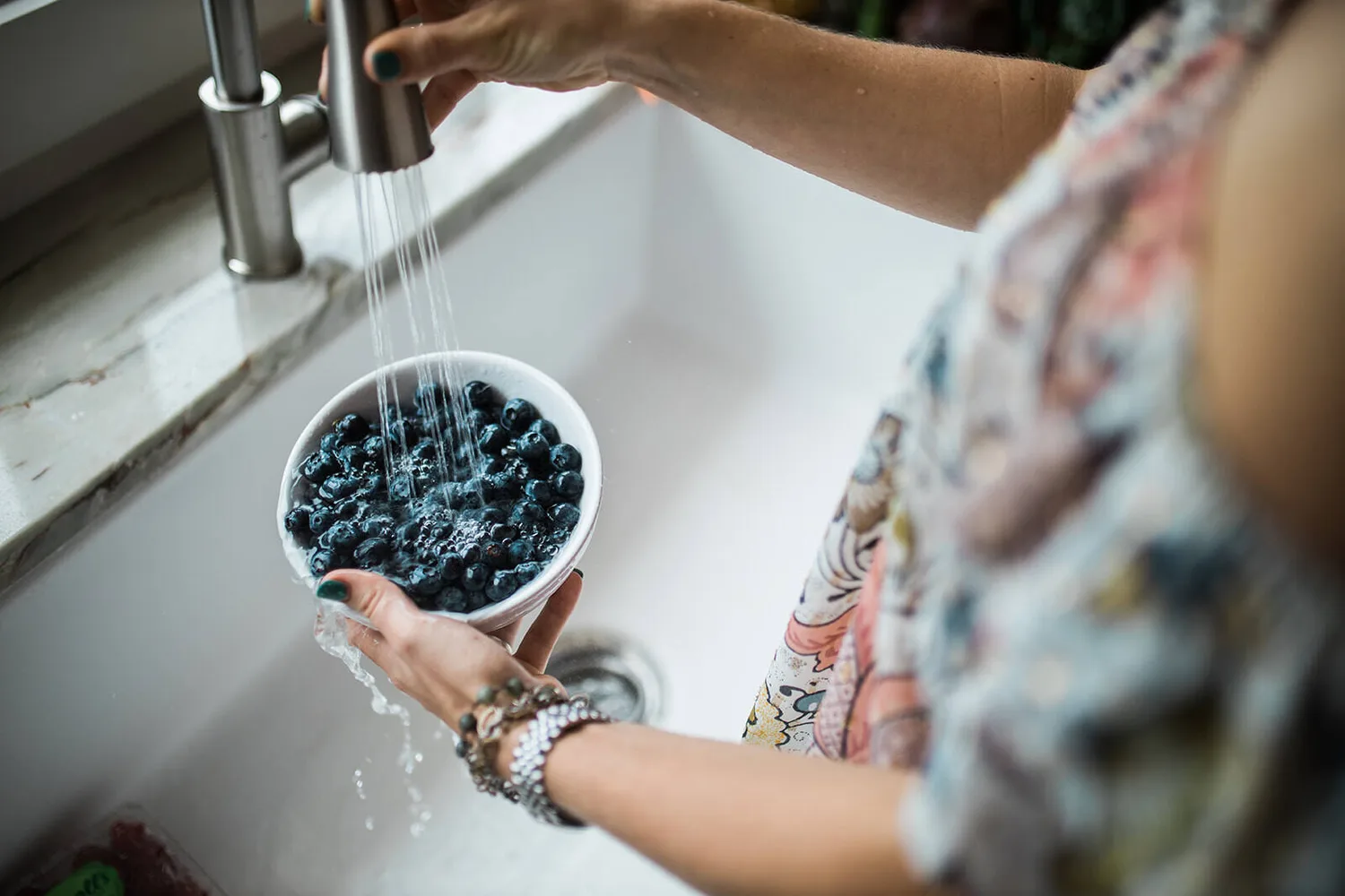 Hands holding a bowl of blueberries